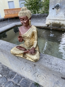 Buddha Statue sitzend am Brunnen fotografiert