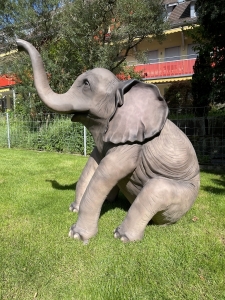 Sitzender Elefant als Gartenfigur, frontal fotografiert.