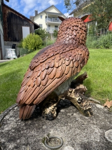 deko-eule auf baumstumpf in der rueckansicht