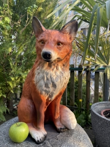 Fuchsfigur sitzend mit gut sichtbarem Kopf und Fellmotiv.