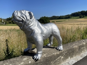 Silberne Bulldogge als Hundefigur in einer hinteren Schraegansicht.