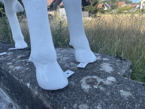 Detail der Fuesse und Standplatte bei der weissen Deko Kuh.