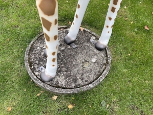 giraffe als gartenfigur mit detail von sockel und hufen