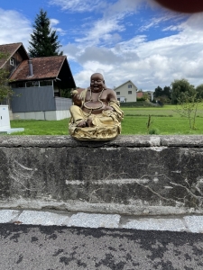 Seitliche Ansicht der Gluecksbuddha Figur mit Goldklumpen