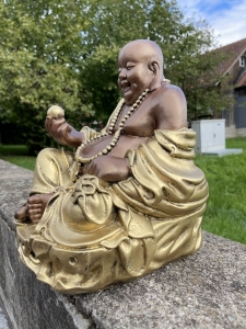 Sockel und Gewand der Gluecksbuddha Figur im Detail