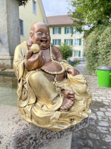 Hand, Schale und Goldklumpen der Buddhafigur im Detail