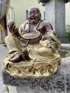 Gluecksbuddha mit Goldklumpen als Gartendeko im Aussenbereich