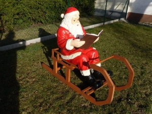 Grosser Weihnachtsmann mit Buch auf Schlitten