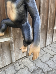 Haengende Affenfigur in einer vorderen Detailansicht.