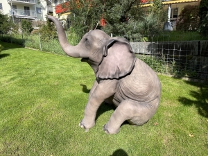 Sitzender Deko Elefant mit seitlicher Koerperform.