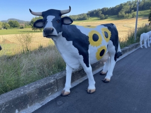 Kuh mit Sonnenblumenbemalung schraeg von vorne