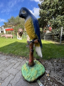 Rueckansicht der blau-gelben Papageienfigur auf Sockel