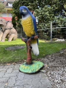 Papageienfigur blau-gelb in schraeger Seitenansicht