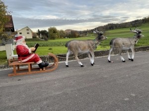 Rentiergruppe mit Weihnachtsmann und Schlitten als Outdoor-Weihnachtsdeko.
