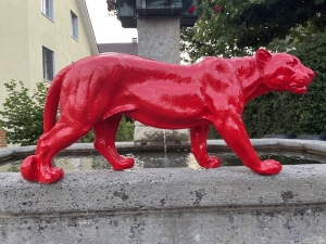 Roter Panther als Dekofigur auf Steinmauer