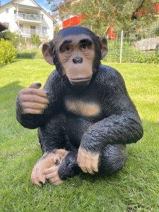 Schimpansenfigur auf Rasen von vorne