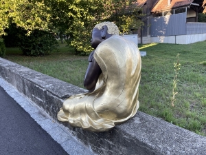 Buddhafigur schwarz-gold am Brunnen fotografiert