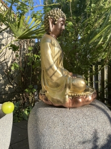 Schraegansicht der goldenen Buddhafigur auf Lotus-Sockel