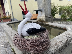 Storch im Nest schraeg von vorne als dekorative Gartenfigur.